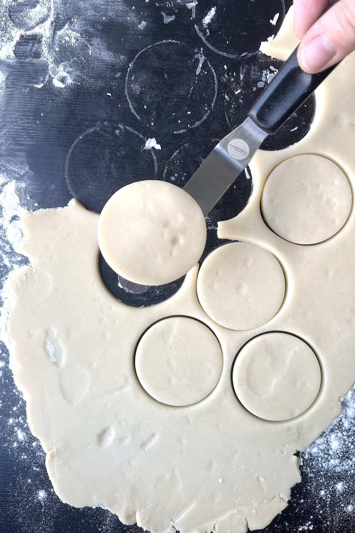 Spatula transferring unbaked cookies to a baking sheet. 