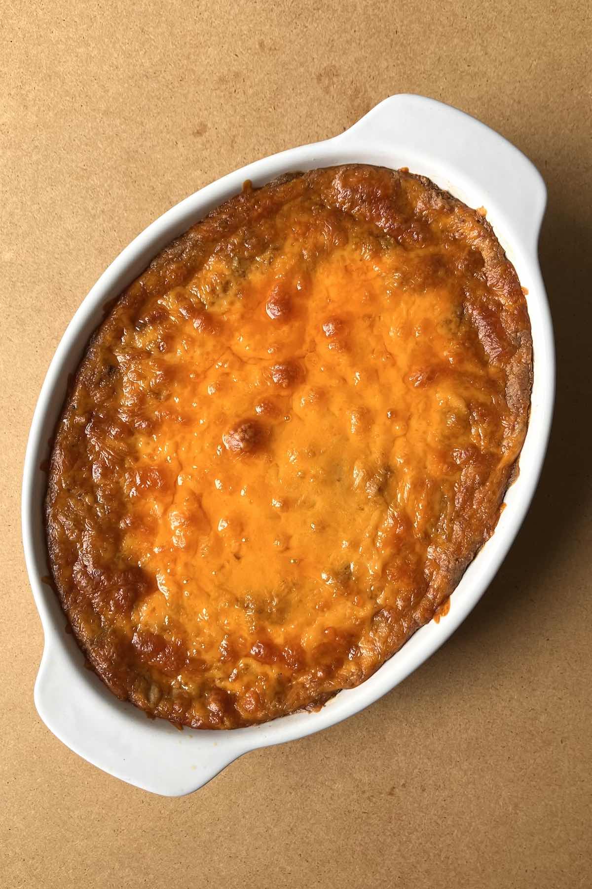 Baked refried bean dip in a white baking dish.
