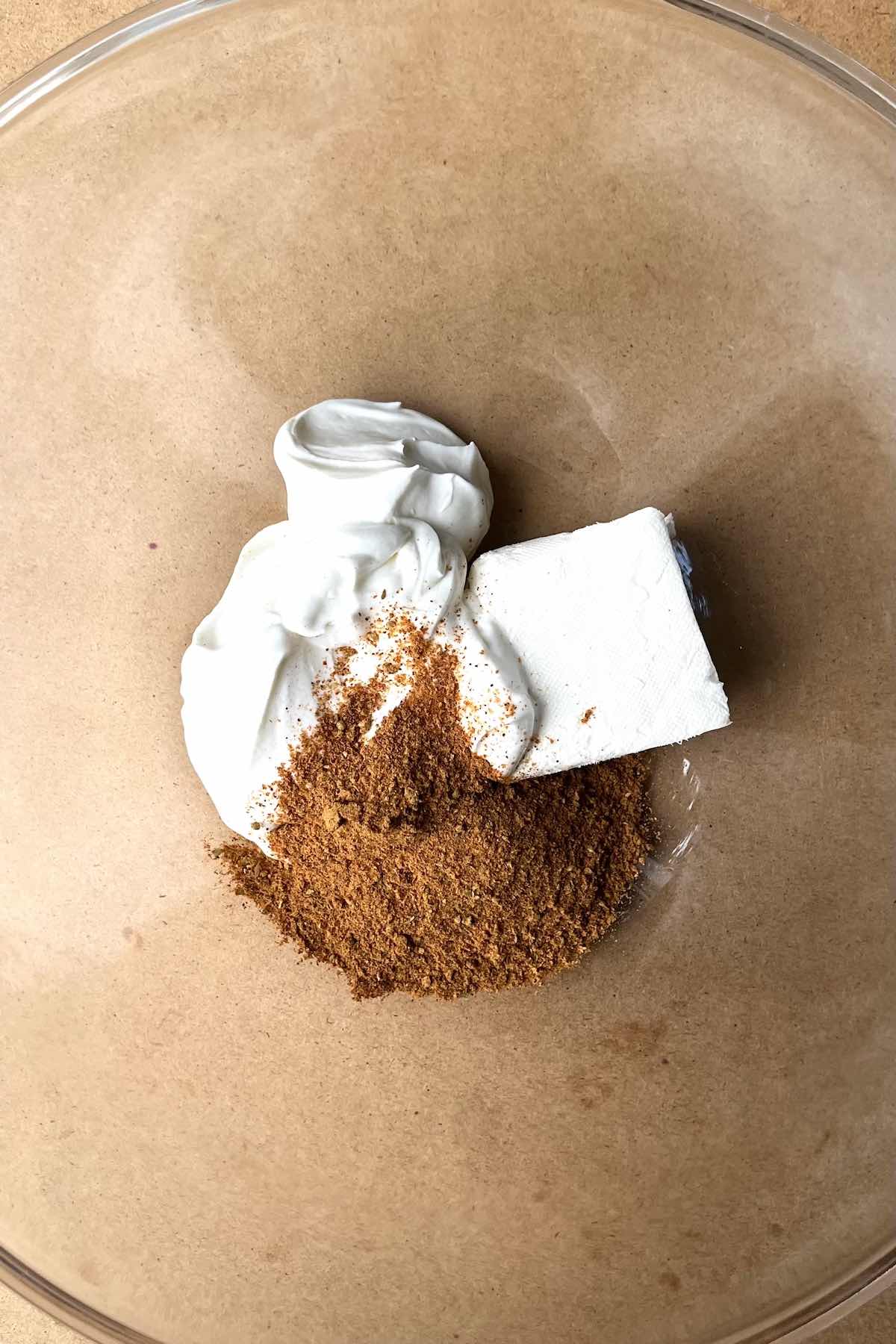 Sour cream, cream cheese, and taco seasoning in a bowl.