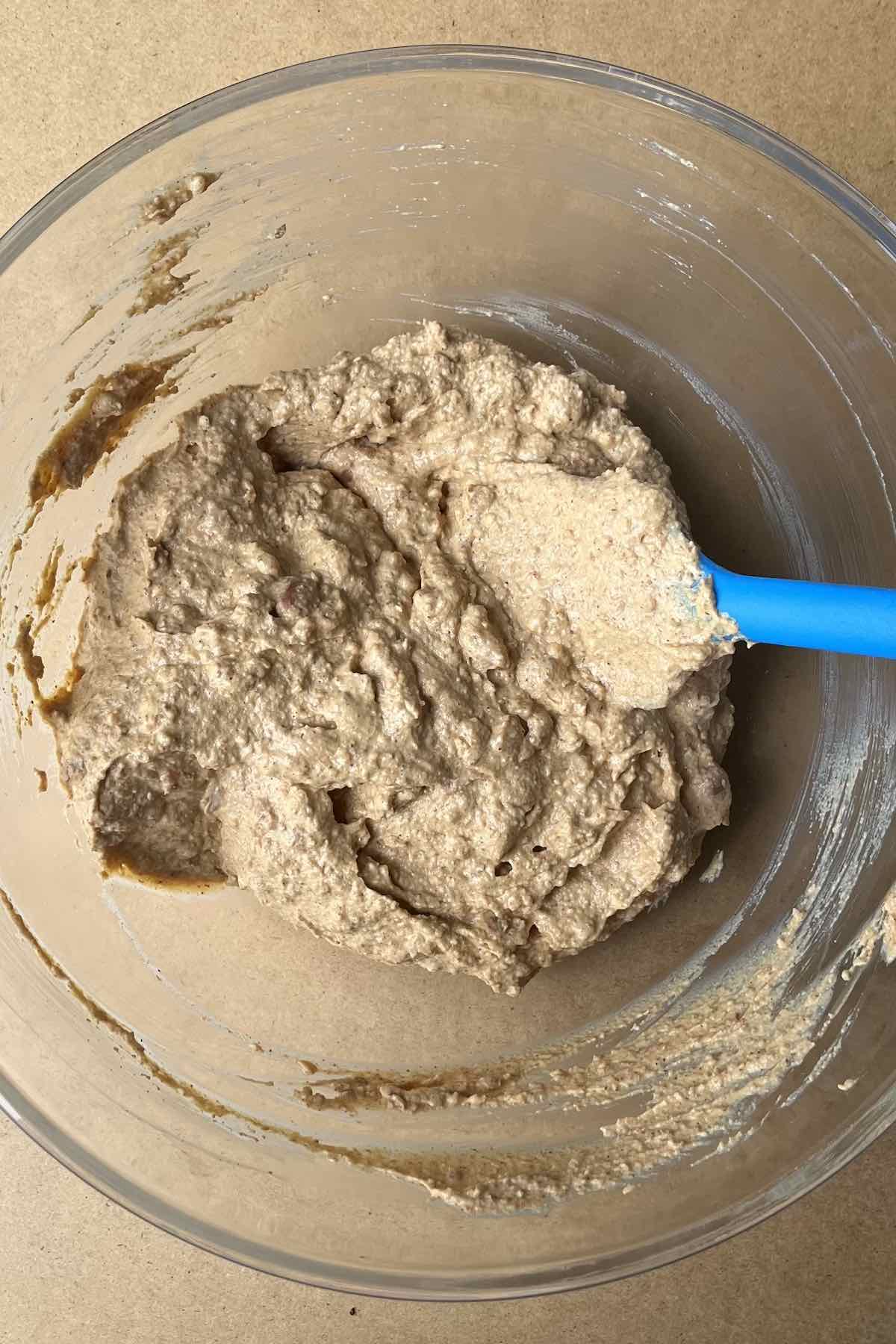 Sour cream, cream cheese, taco seasoning and refried beans mixed in a bowl.