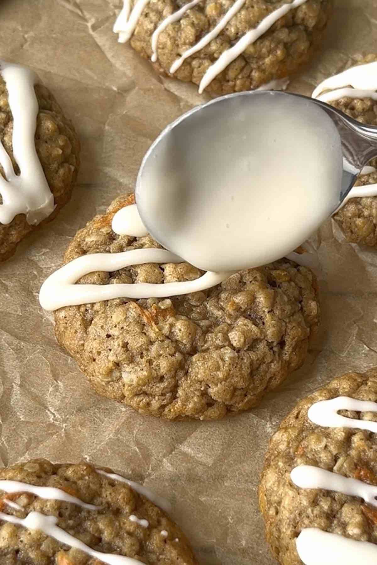 Icing being drizzled over a cookie with a spoon.