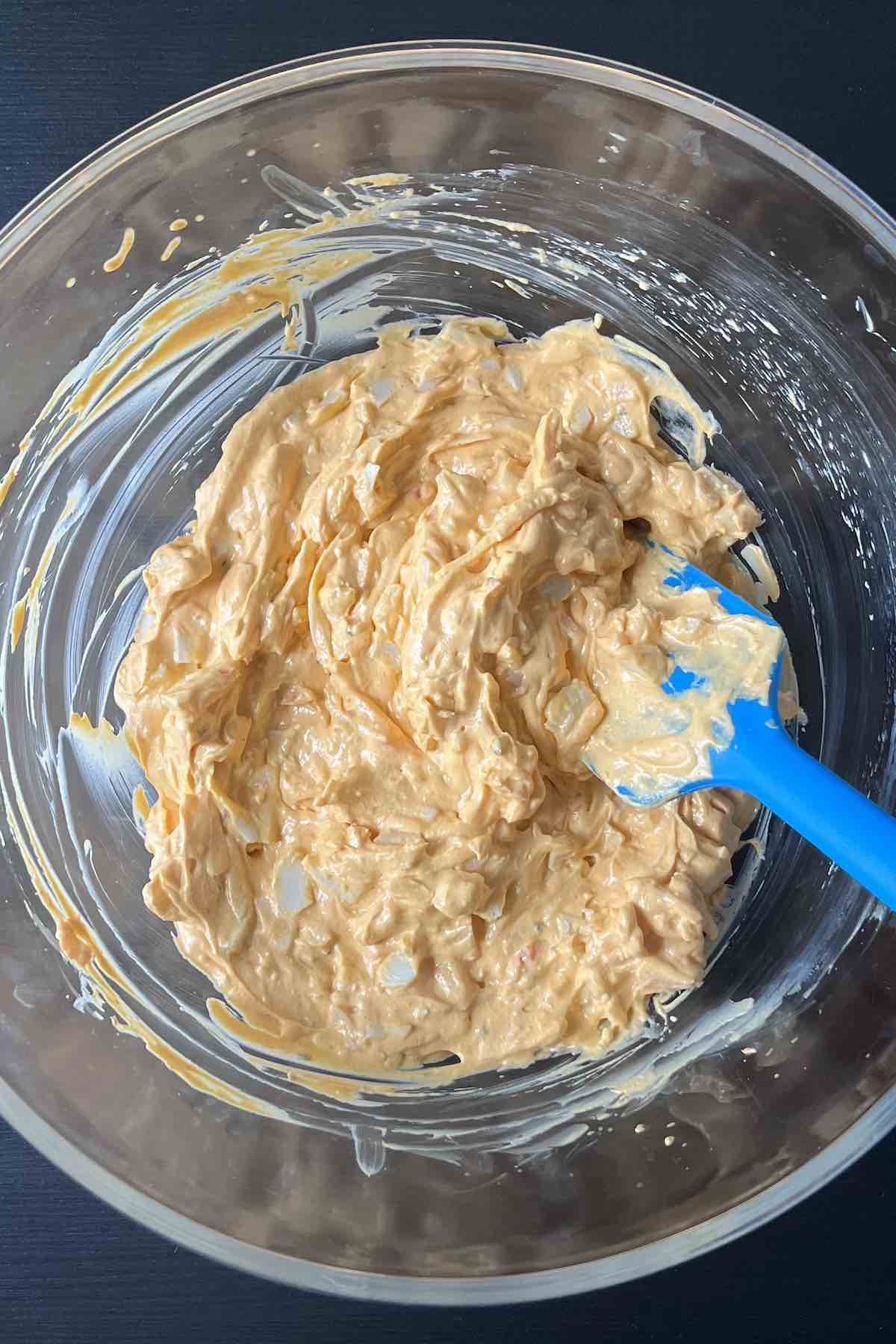 Imitation crab and cheddar cheese folded into the bowl of cream cheese, buffalo sauce, and ranch dressing.