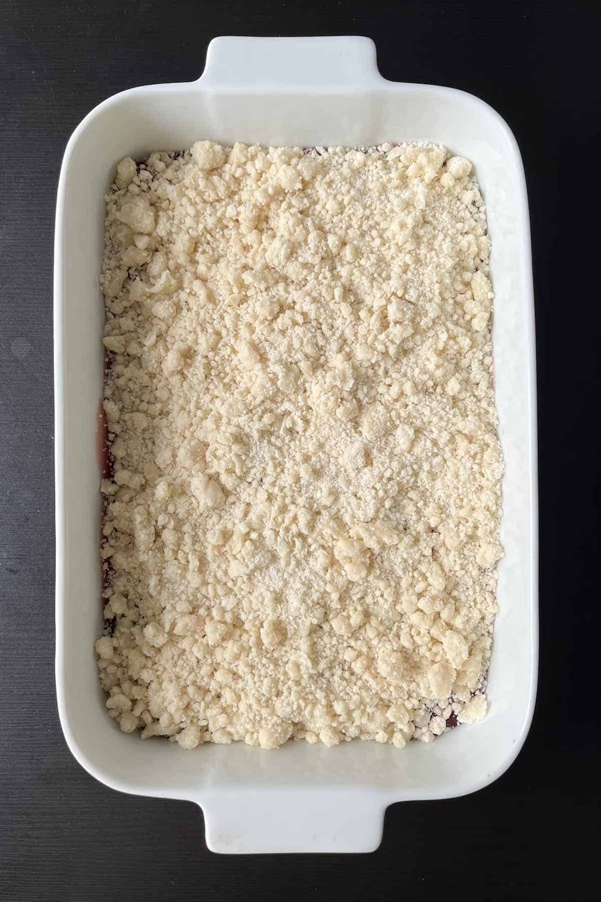 Crumbly mixture on top of the cherry layer, ready for baking.