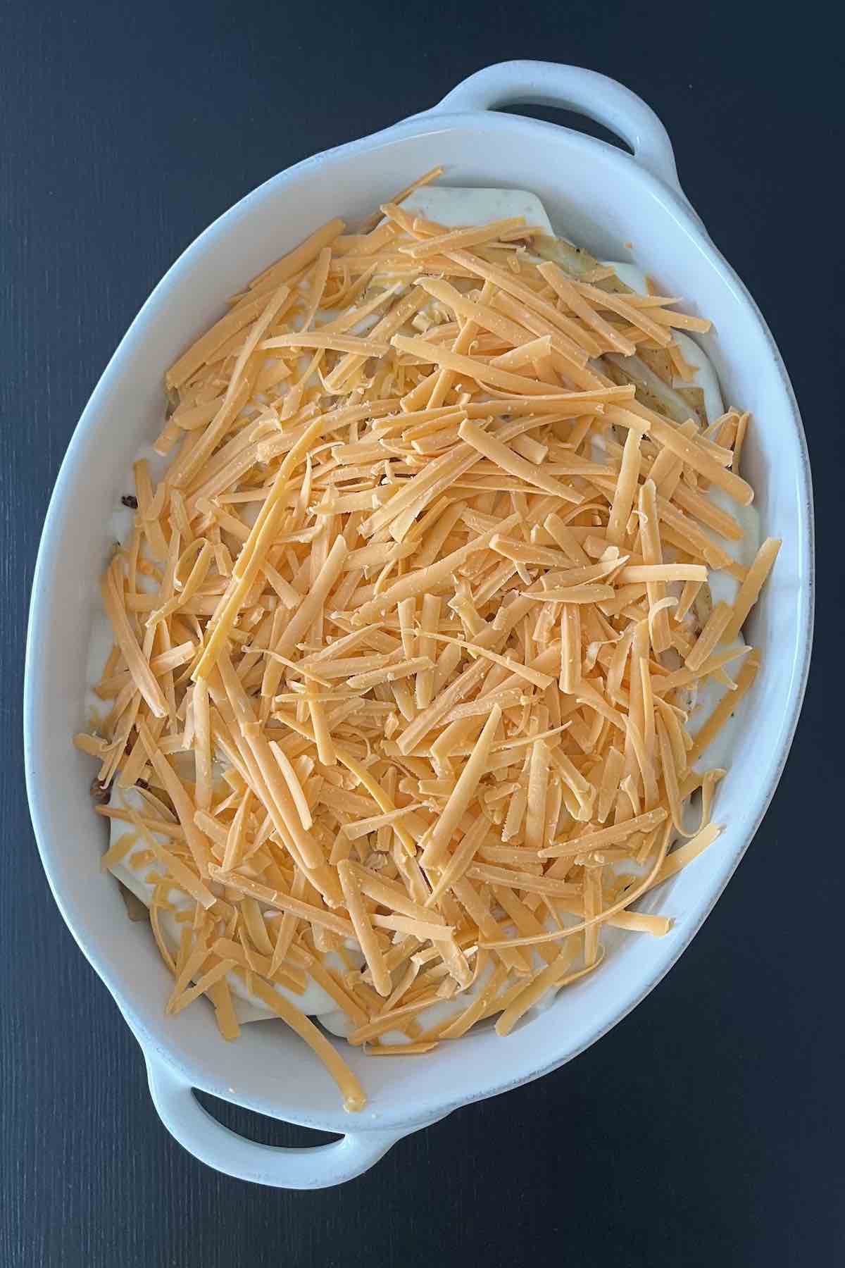Cheese sprinkled on top of the scalloped potatoes.