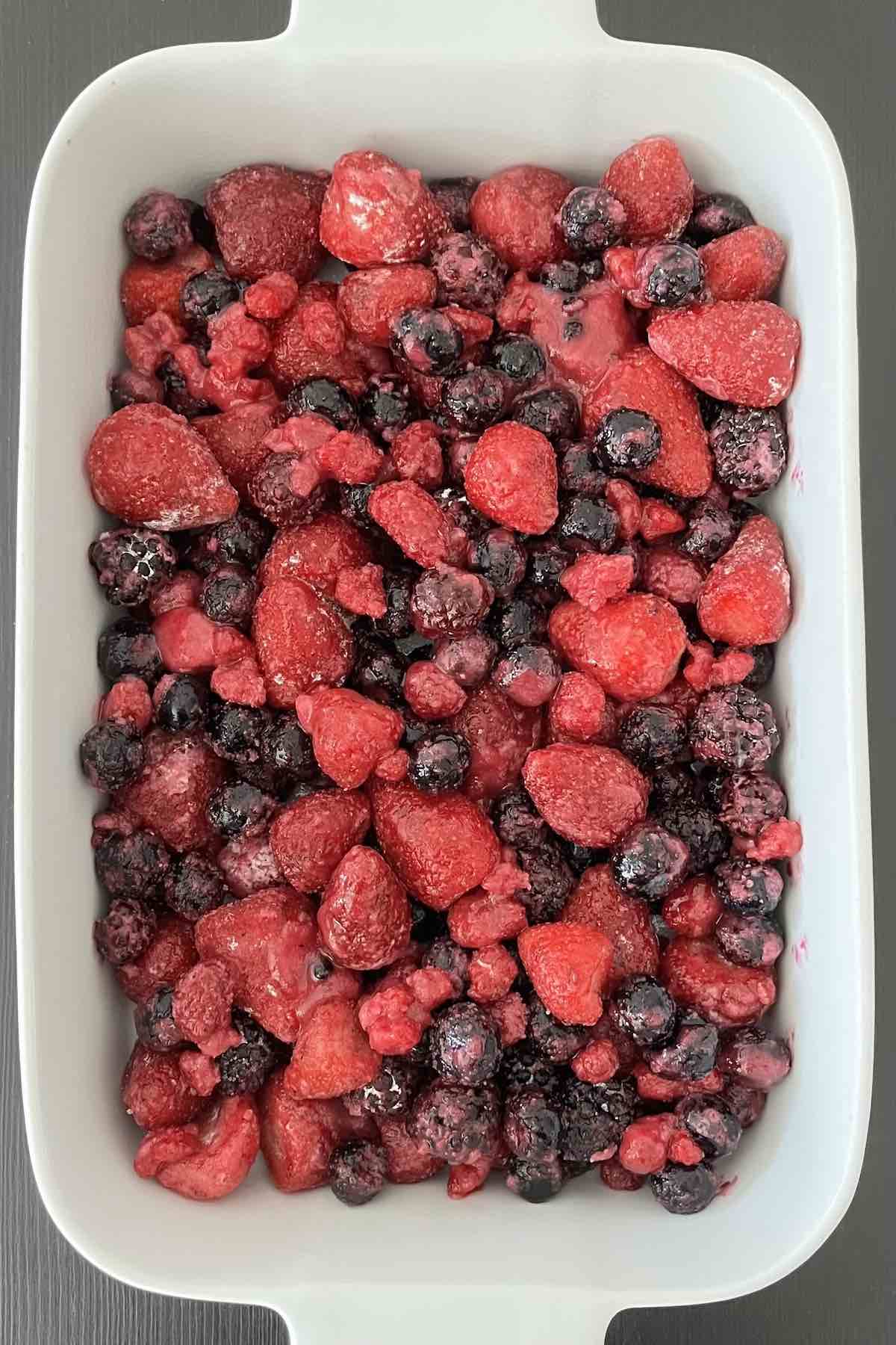 Berry mixture in a white casserole dish.