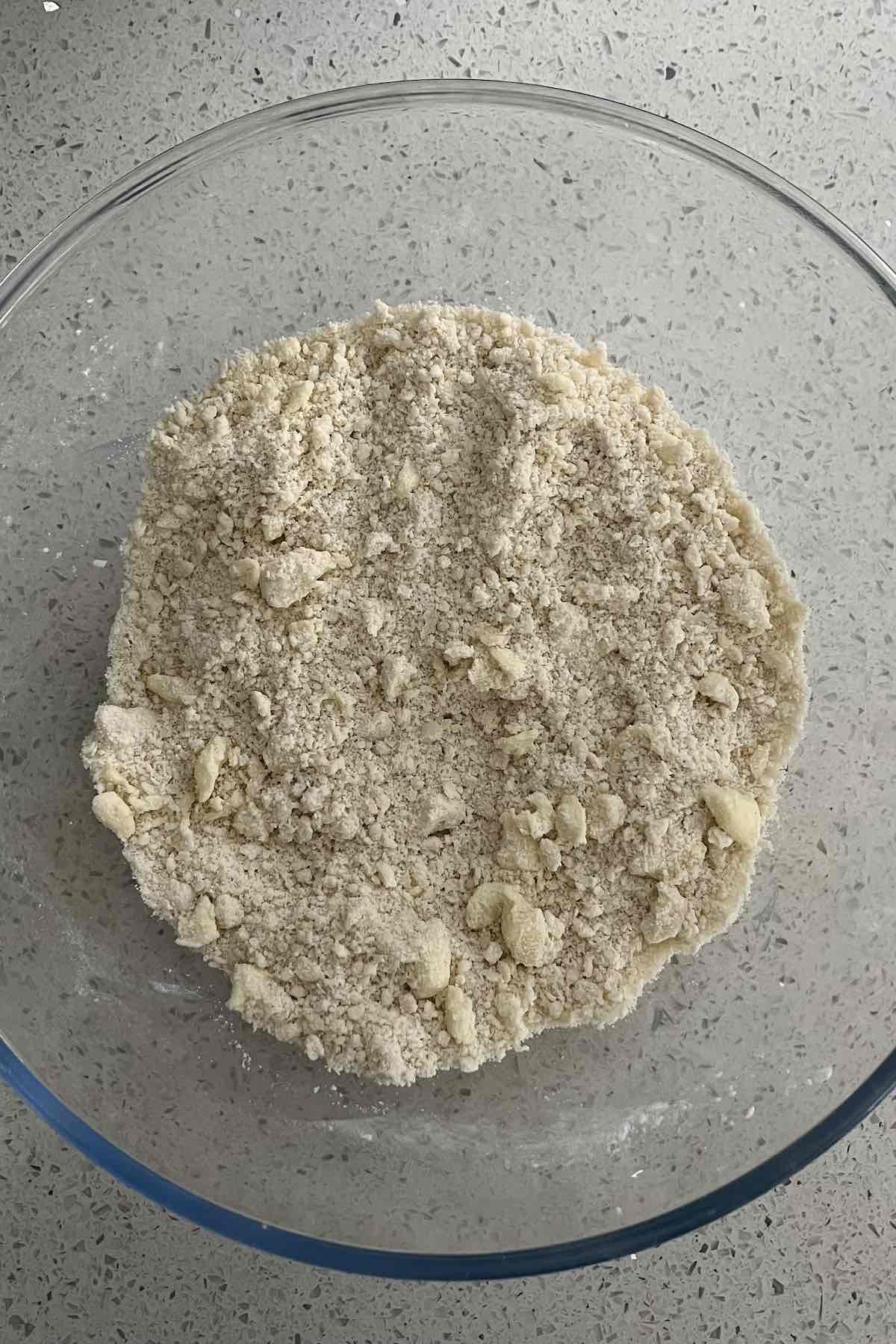 Flour, sugar, salt, and butter mixed together forming a sand-like texture.