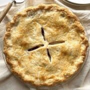 Pie with homemade pie crust in a glass pie dish.