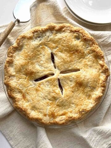 Pie with homemade pie crust in a glass pie dish.