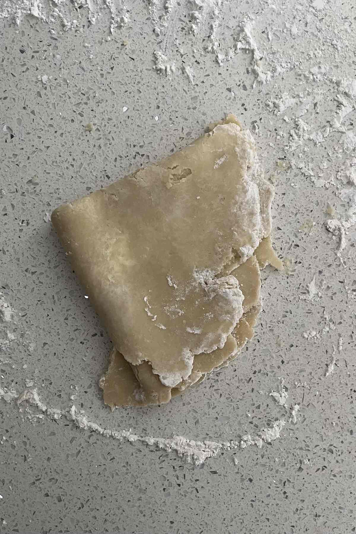 Pie dough folded into 4 quarters.