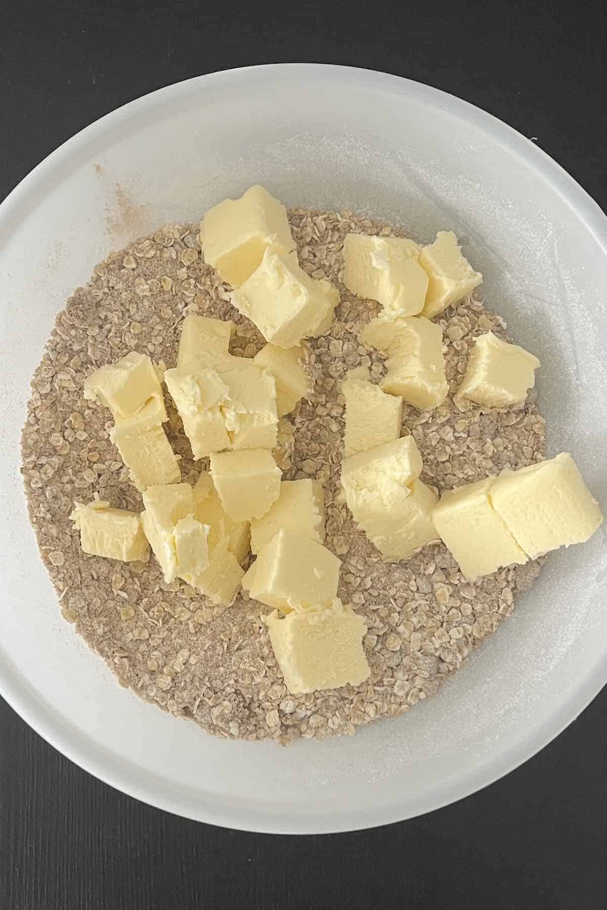 Dry topping ingredients and cubed butter in a bowl.
