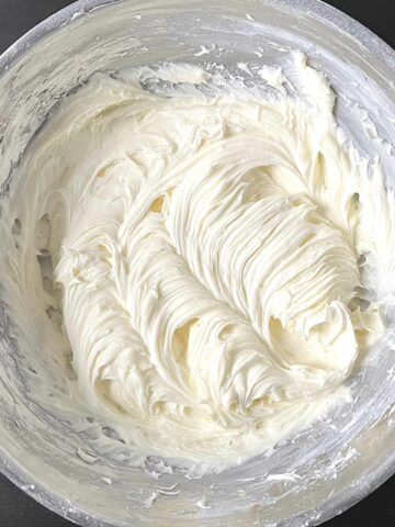 Cream cheese buttercream frosting whipped in a mixing bowl.