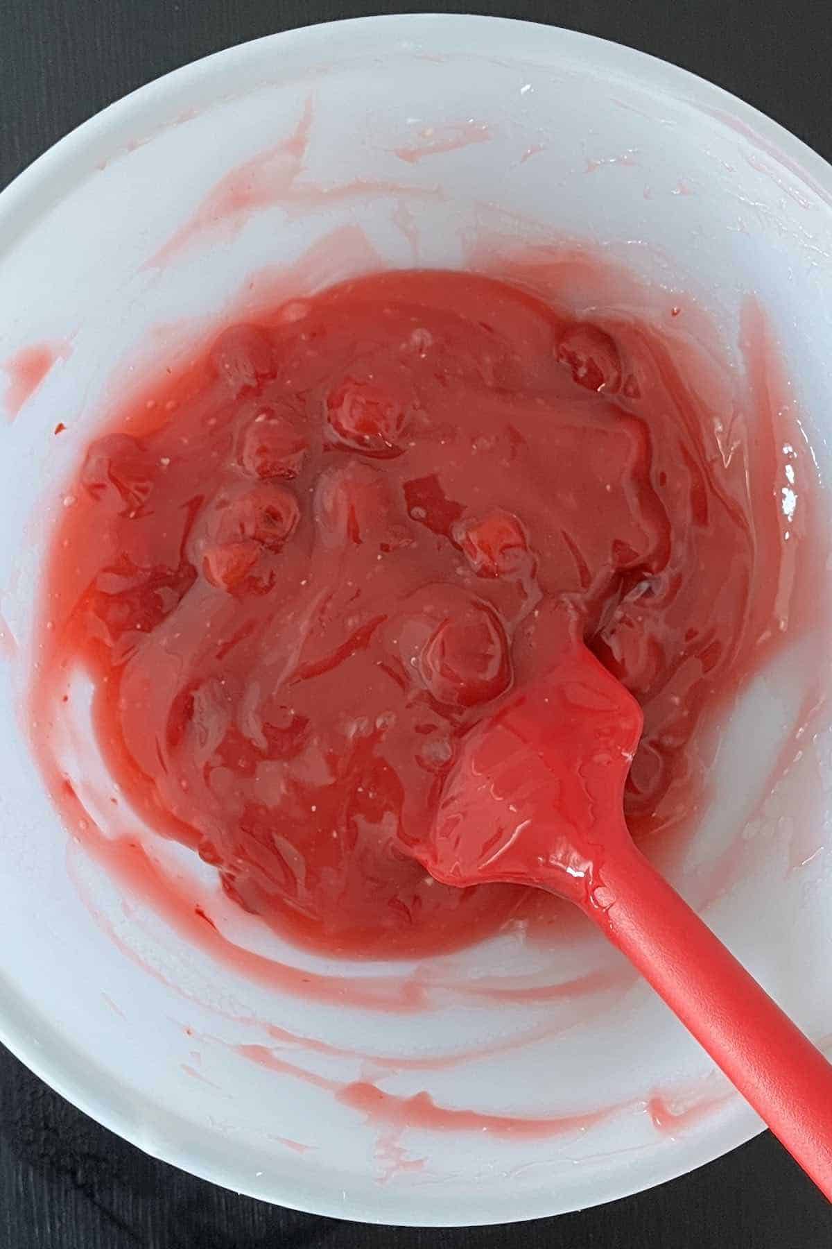 Canned cherry pie filling, cornstarch, vanilla, and lemon juice mixed in a bowl.