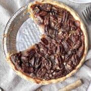 Pecan apple pie with a couple of slices missing from it.