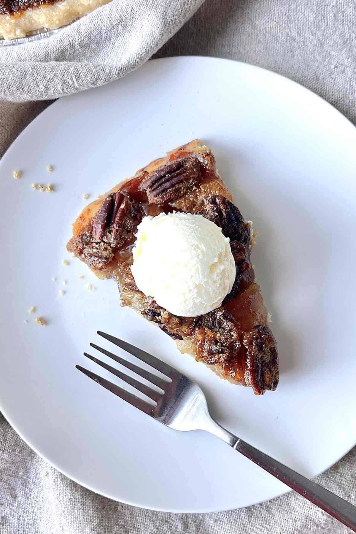 Slice of pecan apple pie on a white plate.