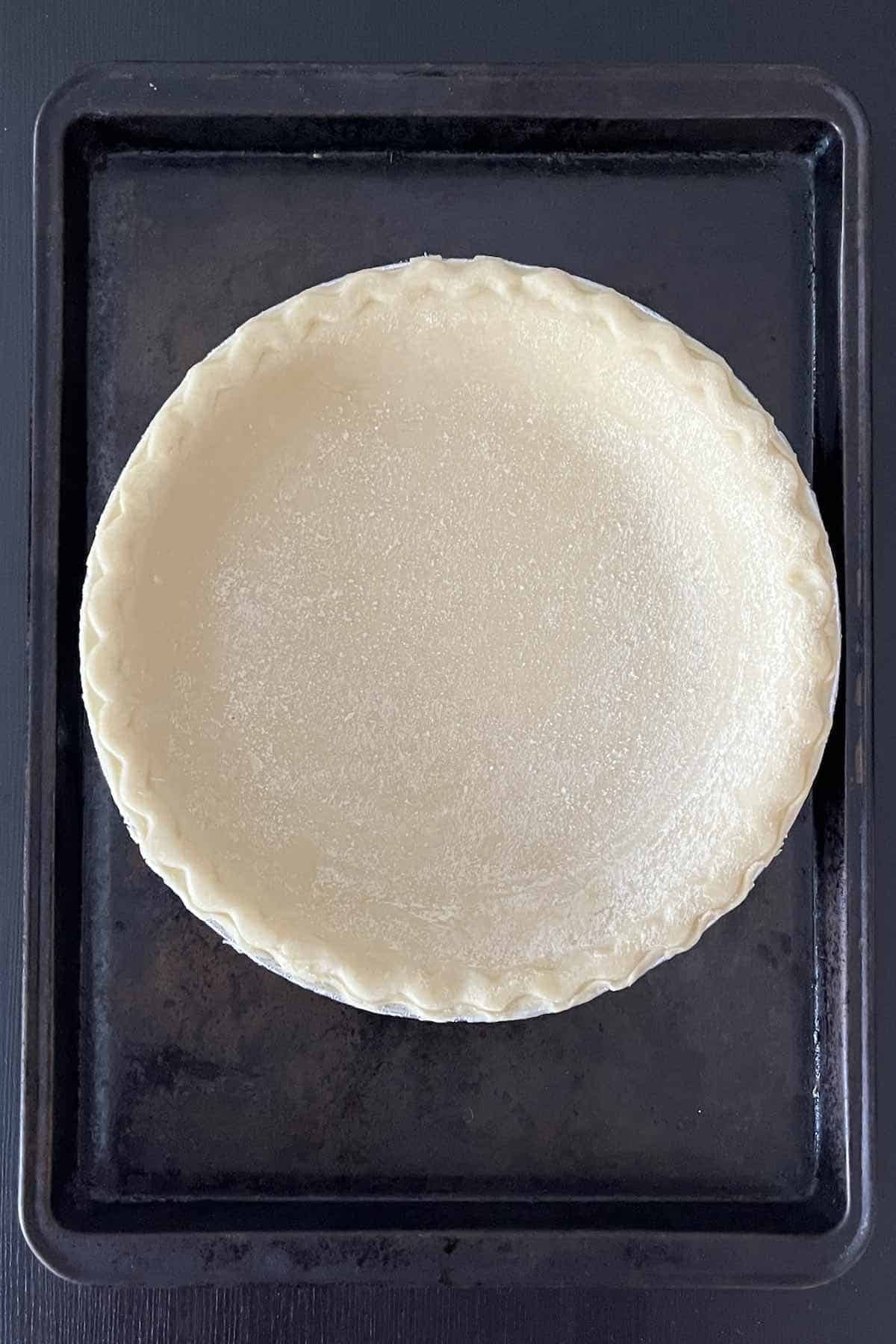 Pie shell on a baking sheet.