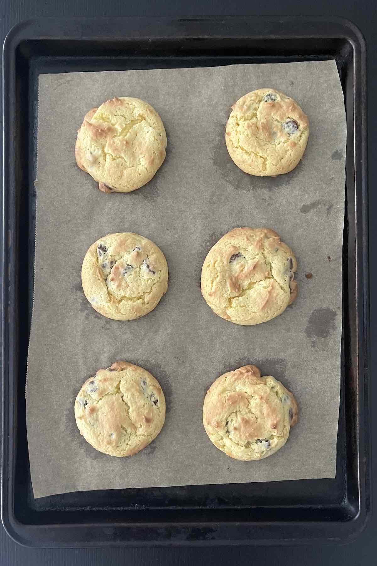 Baked chocolate chip cake mix cookies on a baking sheet.