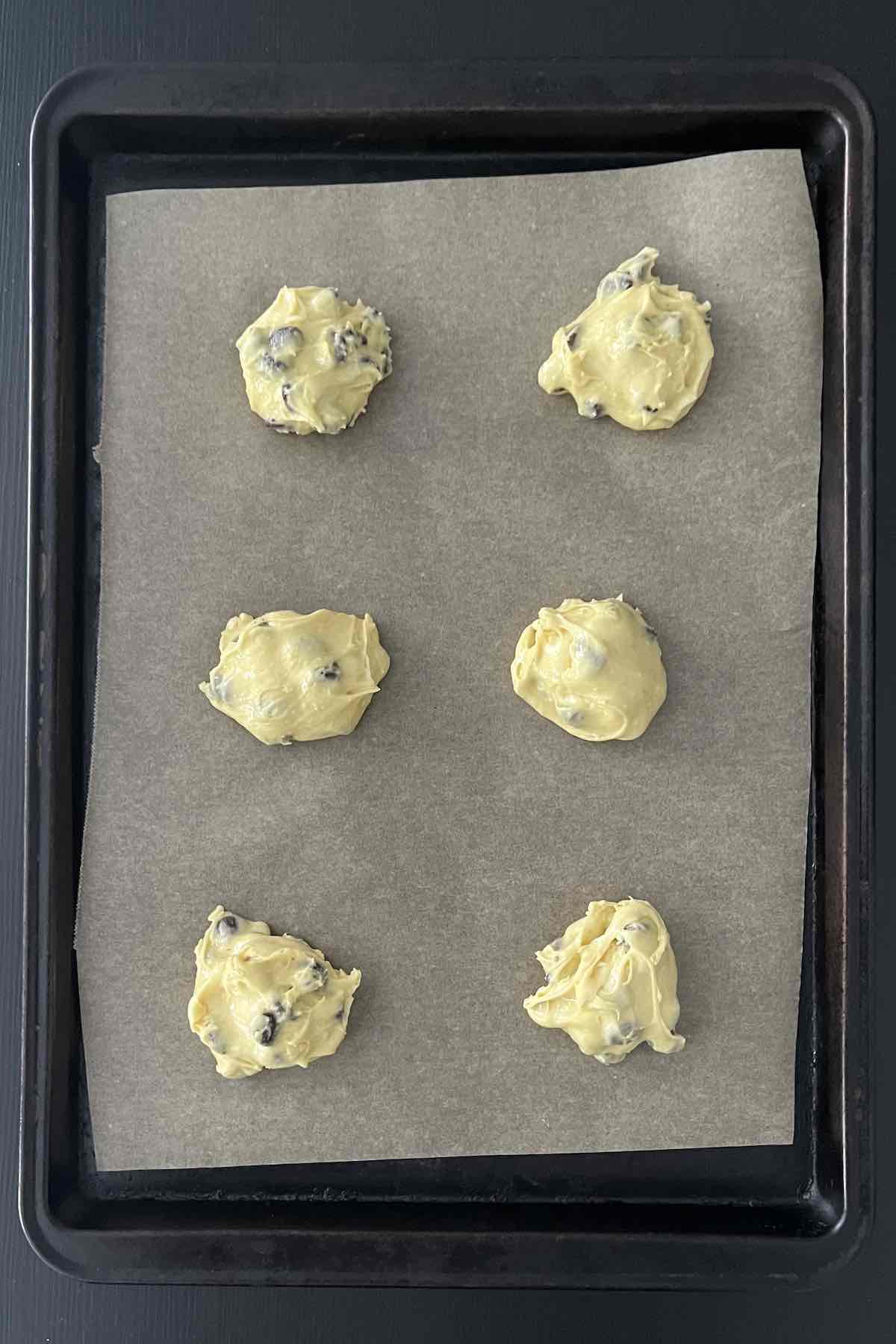 Dollops of cookie dough on a baking sheet.