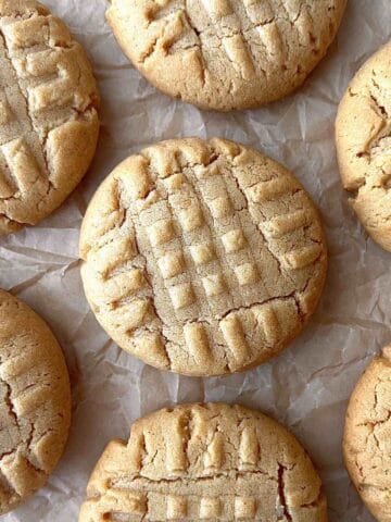 Cake mix peanut butter cookies scattered on a piece of parchment paper.
