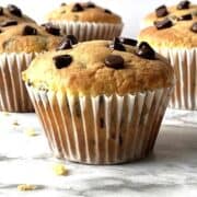 Chocolate chip cake mix muffins next to each other on a marbled white counter top.