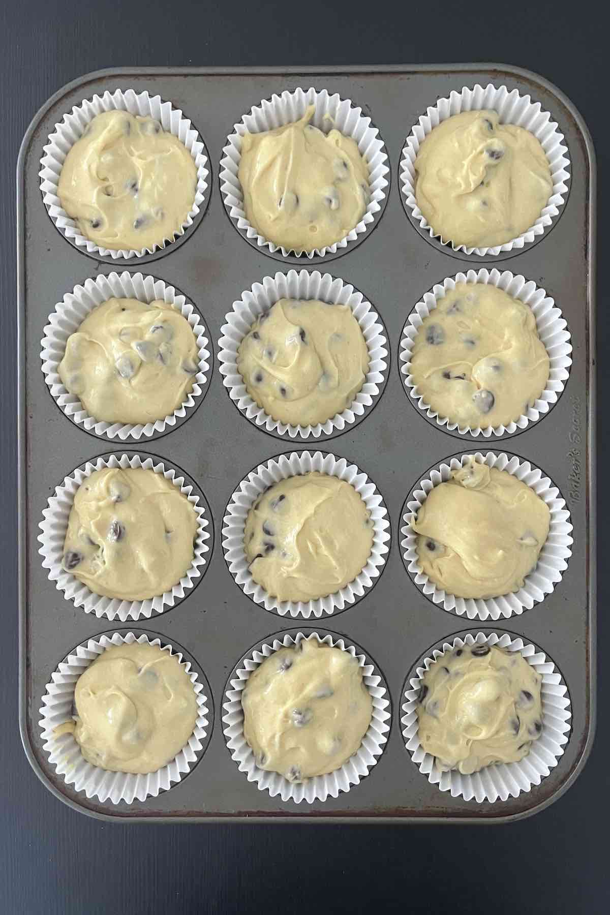 Muffin liners filled with muffin batter.