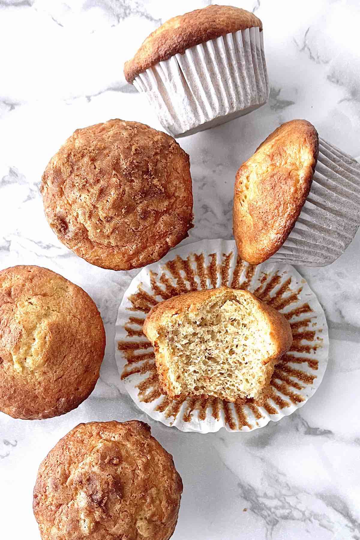 Cake mix banana muffins scattered on a counter top.