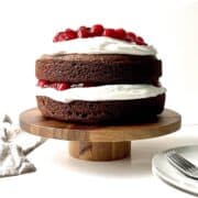 Black forest cake on a wooden cake stand.