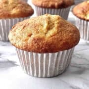 Cake mix banana muffin on a counter with more muffins in the background.