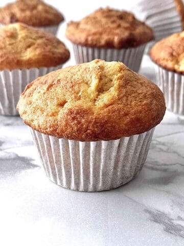 Cake mix banana muffin on a counter with more muffins in the background.
