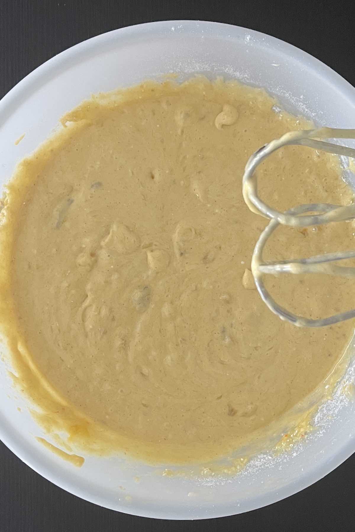 Mashed bananas, eggs, and cake mix combined in a bowl.