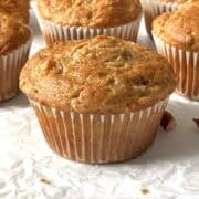 Carrot cake mix muffins scattered on a white piece of parchment paper.