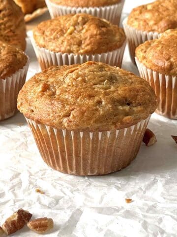 Carrot cake mix muffins scattered on a white piece of parchment paper.