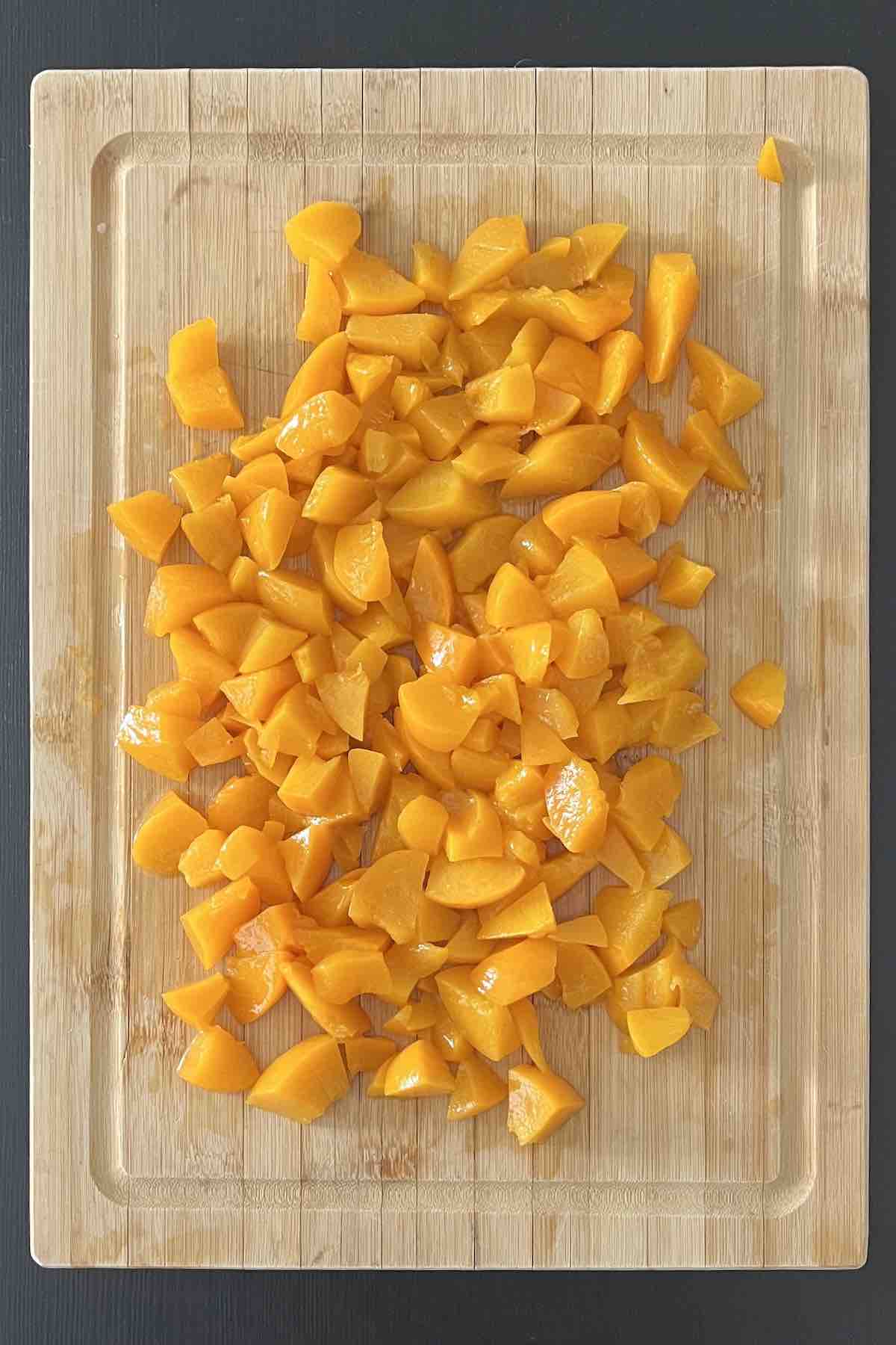 Chopped peaches on a cutting board.