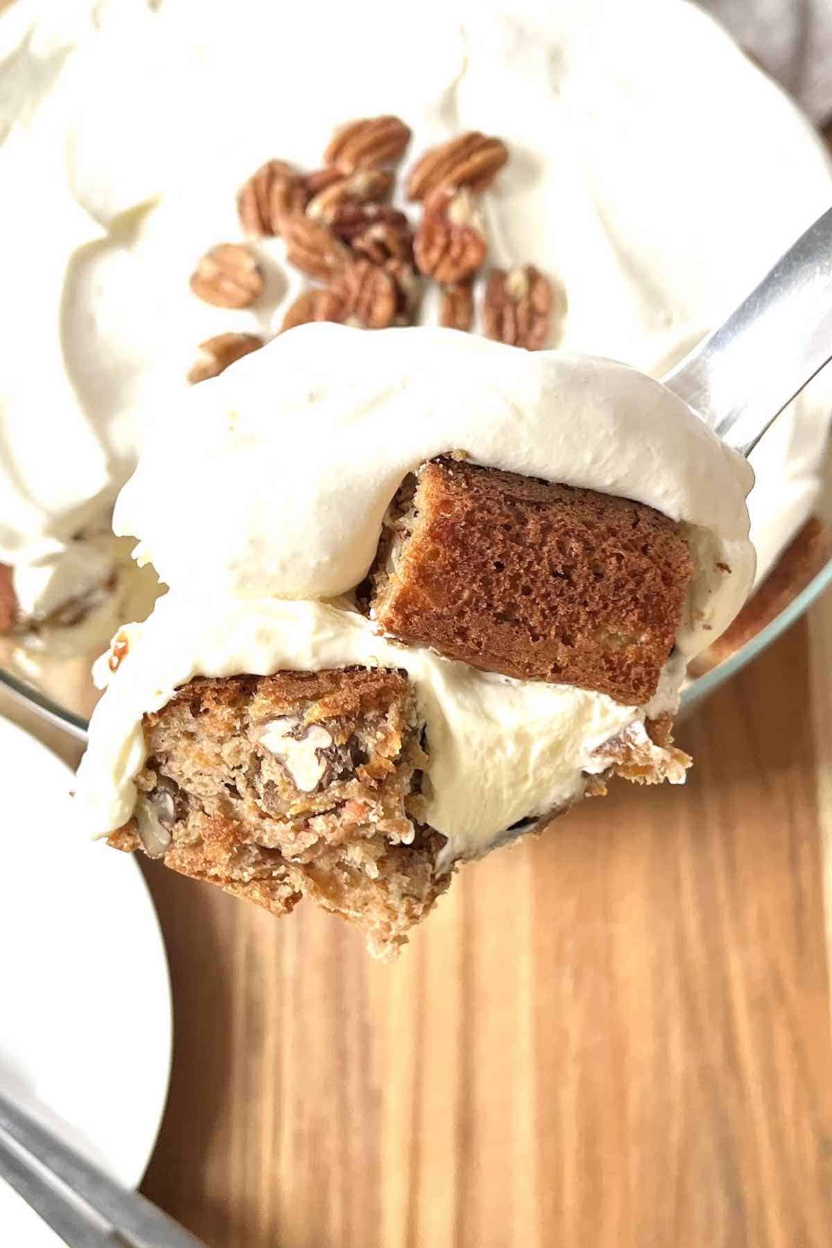 Spoon with a scoop of the carrot cake trifle on it.