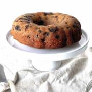 Lemon blueberry cake on a white cake stand.