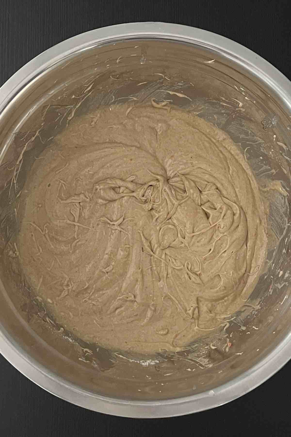 Spice cake mix, milk, melted butter, and eggs mixed in a bowl.