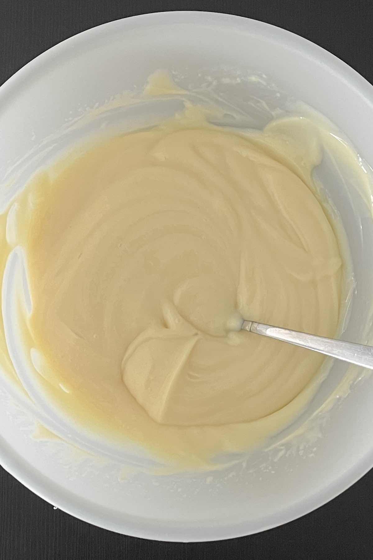 Condensed milk and lemon juice mixed in a bowl.