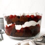 Black forest trifle in a glass trifle dish on a white table.