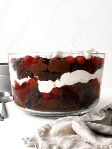 Black forest trifle in a glass trifle dish on a white table.