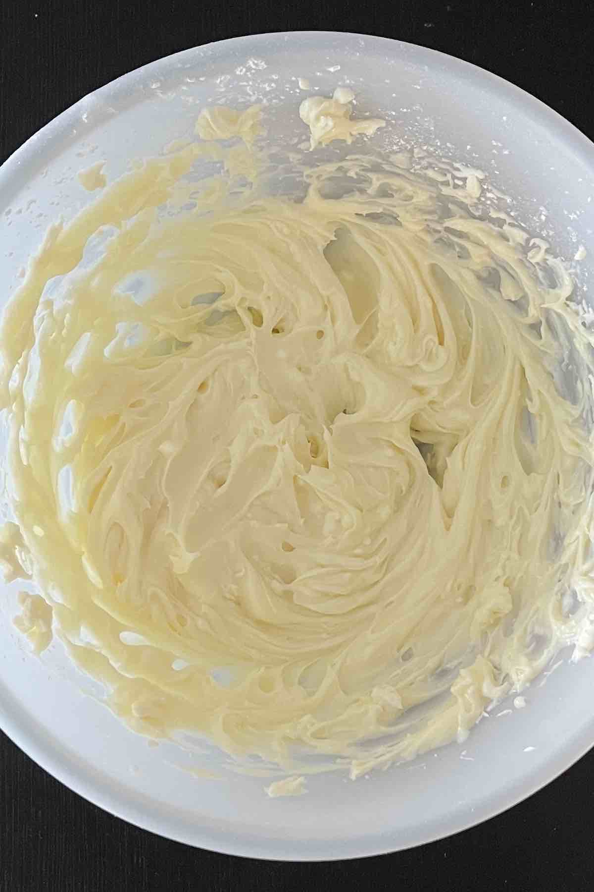 Cream cheese and sugar mixed together in a bowl.