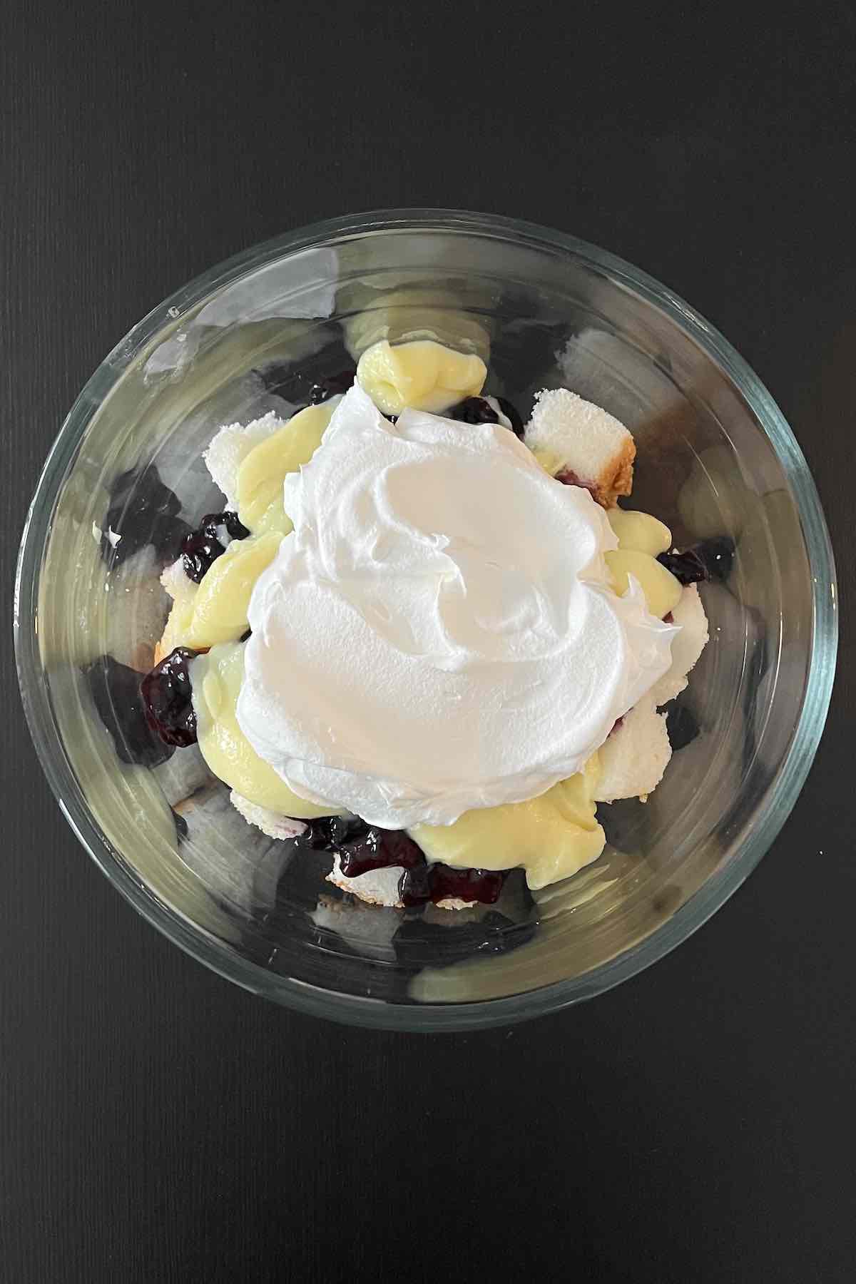 Layer of cake, blueberry filling, vanilla pudding and cool whip in a trifle dish.