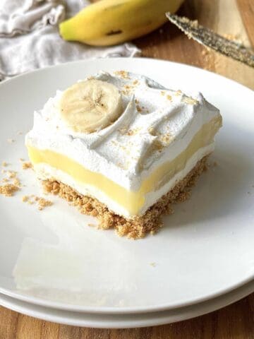 Slice of banana cream delight on a white plate.