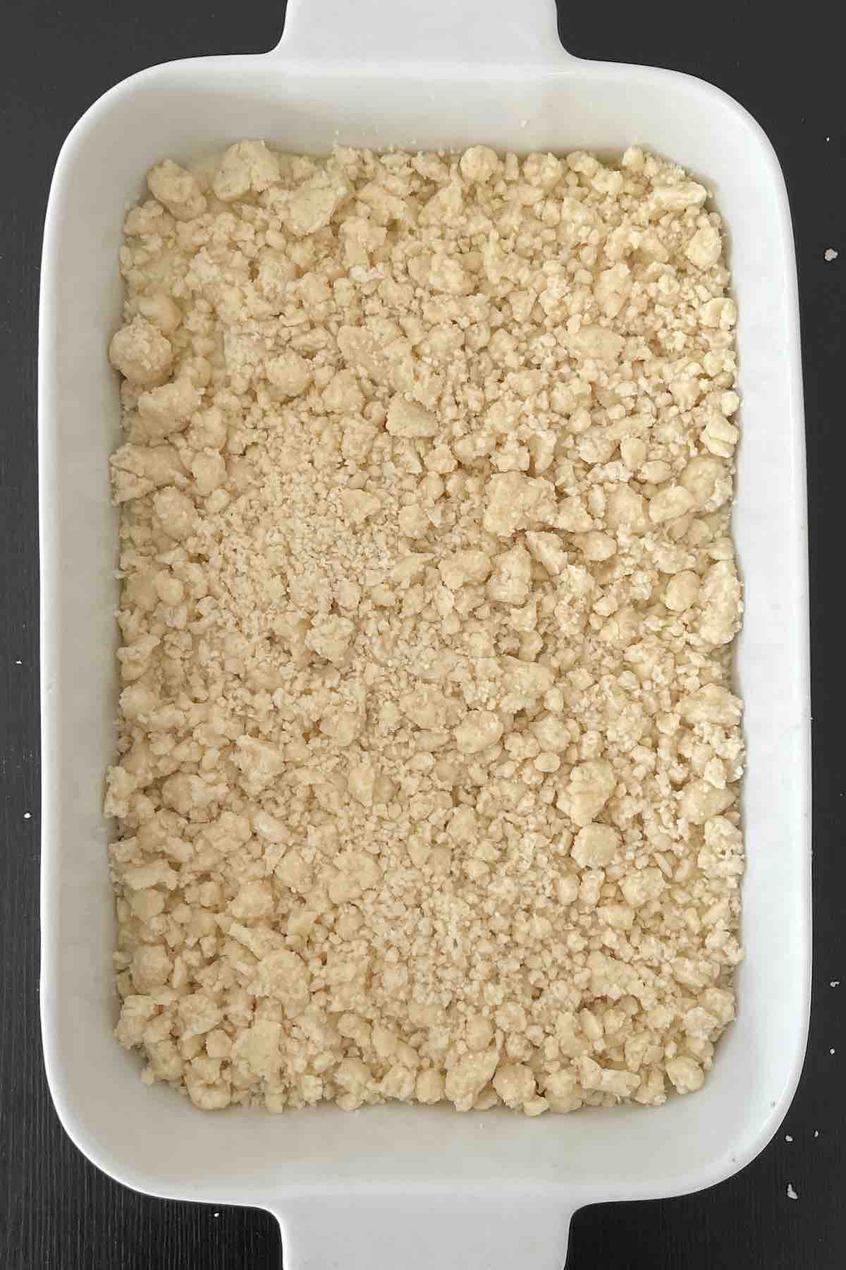 Crumble sprinkled over the key lime filling in the baking dish.