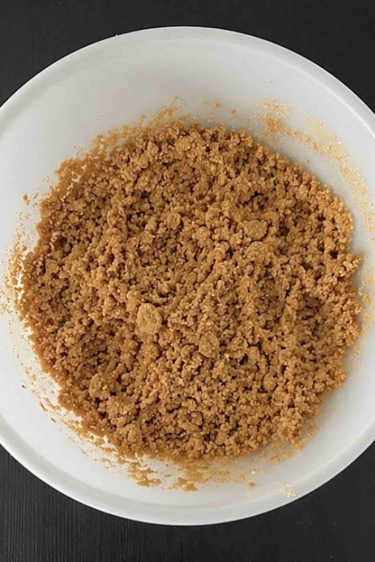 Graham cracker crumbs and melted butter mixed together in a bowl.