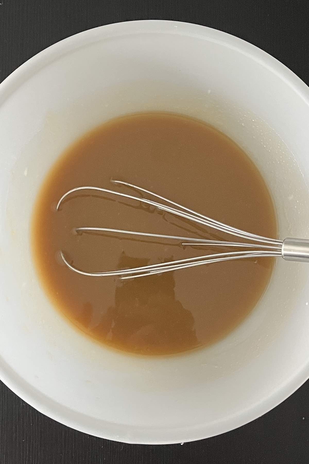 Vanilla pudding, milk and root beer mixed together in a bowl.