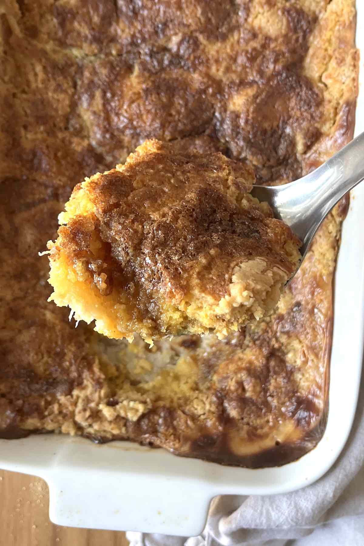 Scoop of banana dump cake on a serving spoon.
