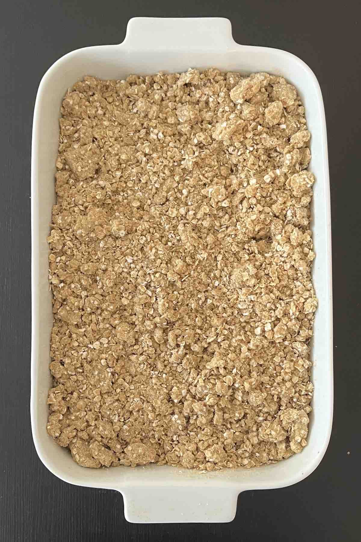 Crisp mixture sprinkled on top of the cherry pie filling in a baking dish.