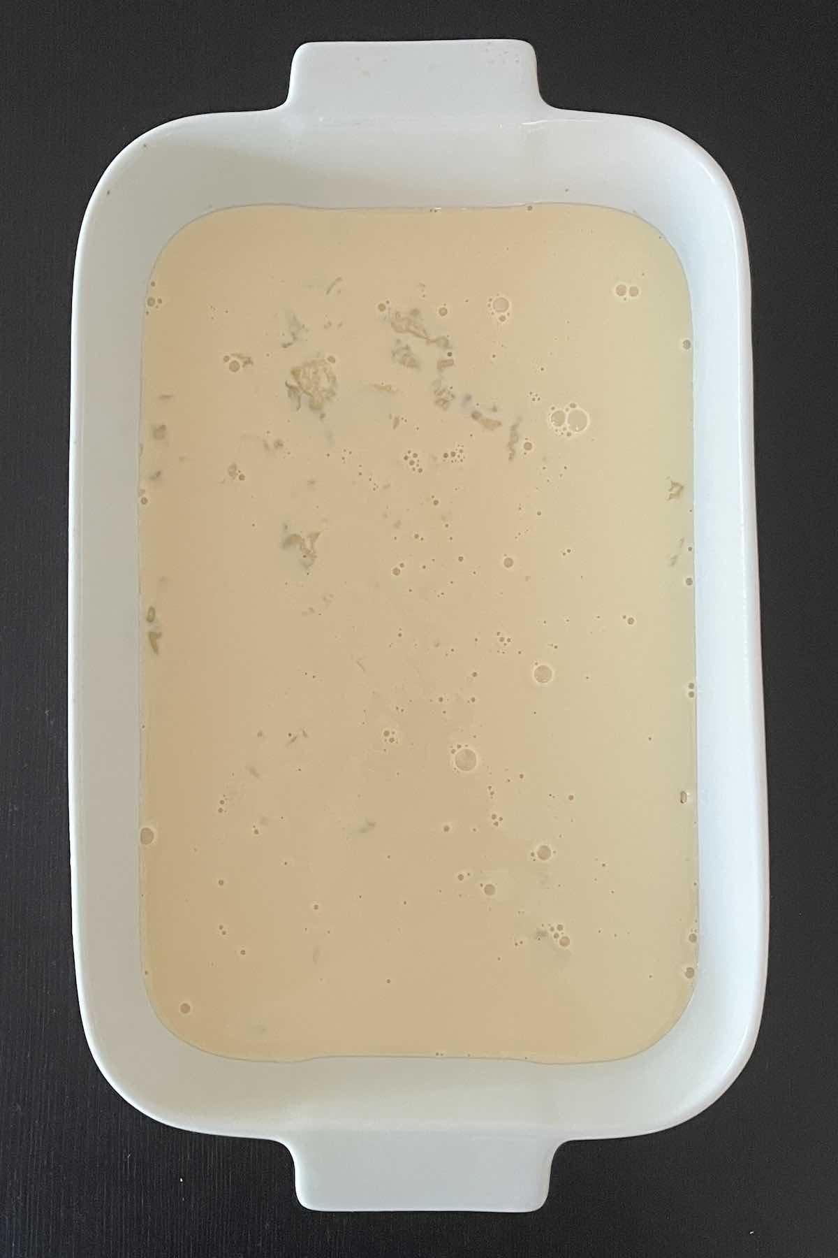 Pecans, milk, and vanilla in a baking dish.