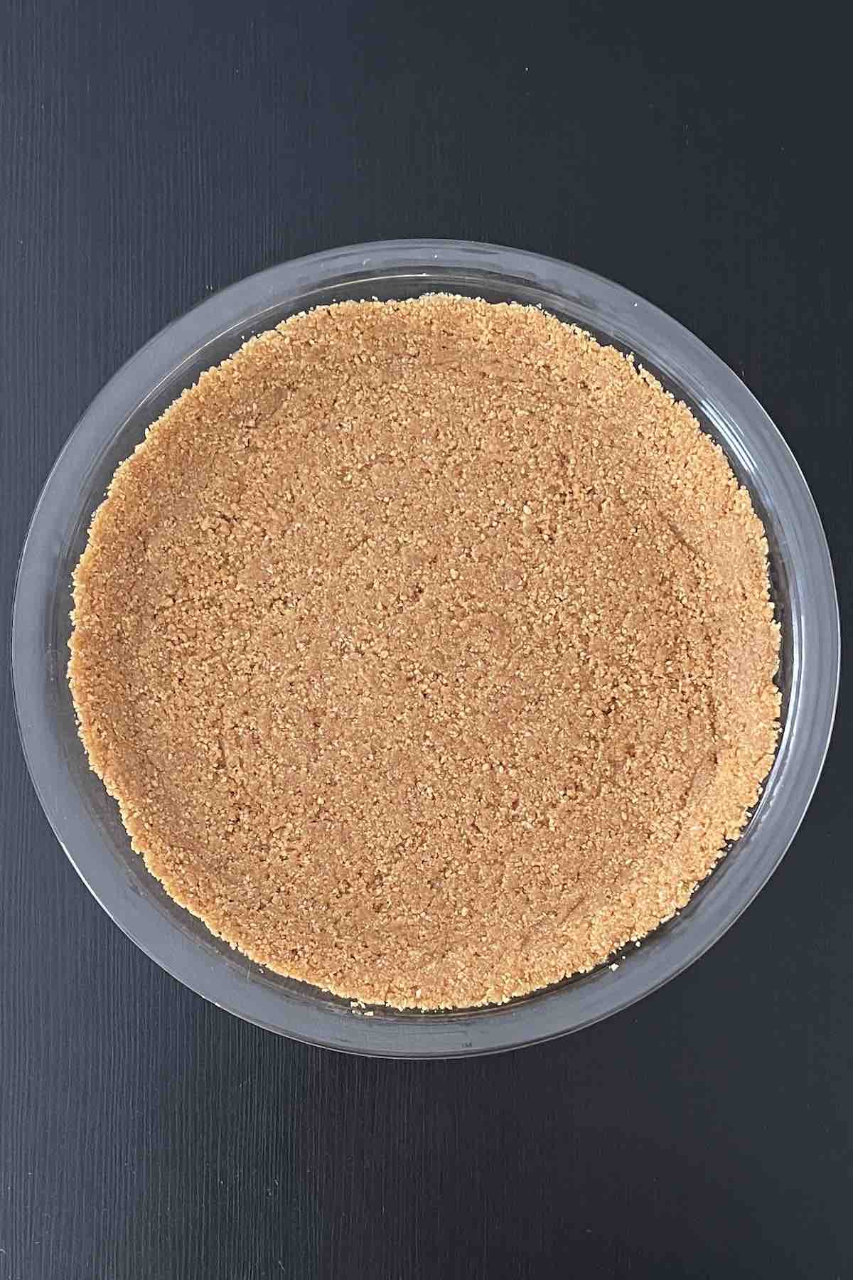Graham cracker pie crust mixture pressed into a pie dish.