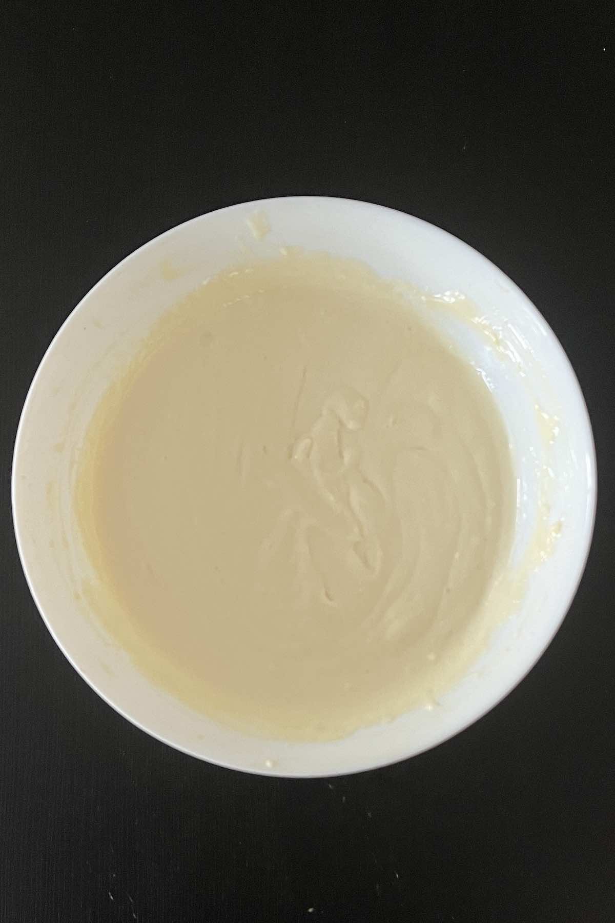 Cream cheese, condensed milk, lemon juice, and vanilla mixed together in a bowl.