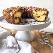 Cake mix coffee cake on a white cake stand with forks and plates in the background.